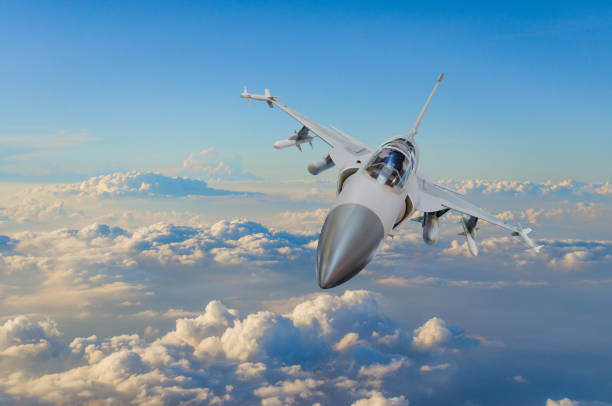 istock Military fighter jet against a blue sky with a backlight from below. 855074124