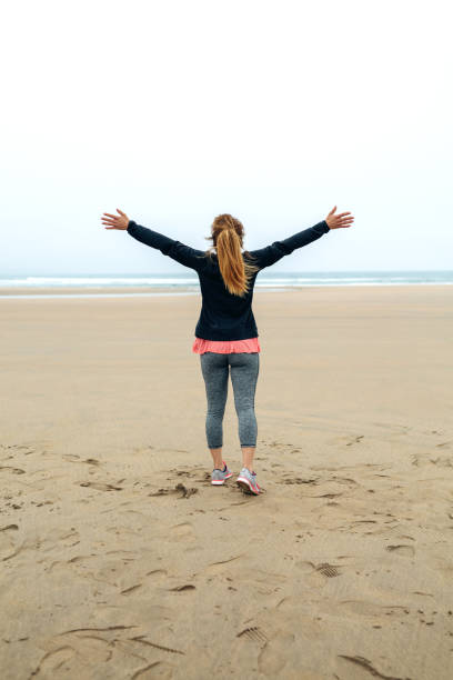 istock Young woman watching the sea with hands up 855074588