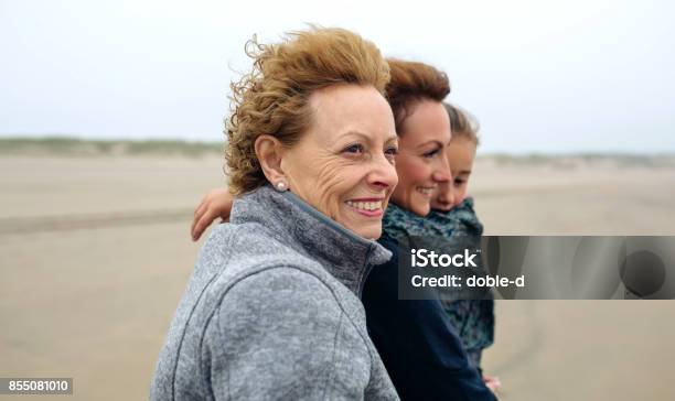 Three Generations Female Walking On The Beach Stock Photo - Download Image Now - Lifestyles, Senior Women, Senior Adult