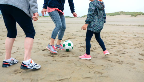 istock Three generations female playing soccer on the beach 855083316