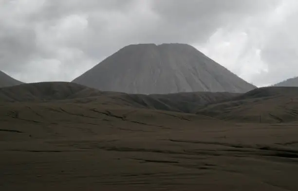 Brown sandy foot of mount Batok early in the afternoon at the Tengger Semeru National Park in East Java, Indonesia.