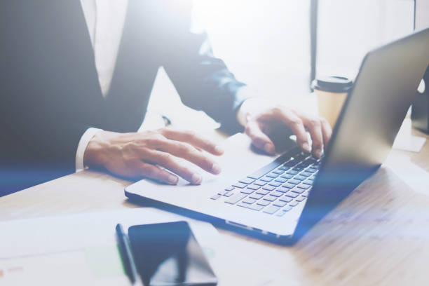 istock Businessman working at sunny office on laptop.Male hands pointing on notebook keyboard.Blurred background.Sunlight effects. 855086264
