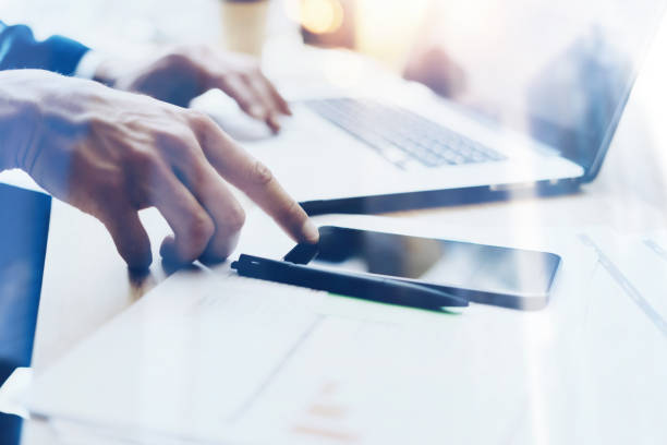 istock Man working on modern mobile phone at office and pointing finger to home button.Horizontal closeup view, blurred background, visual effects. 855086840