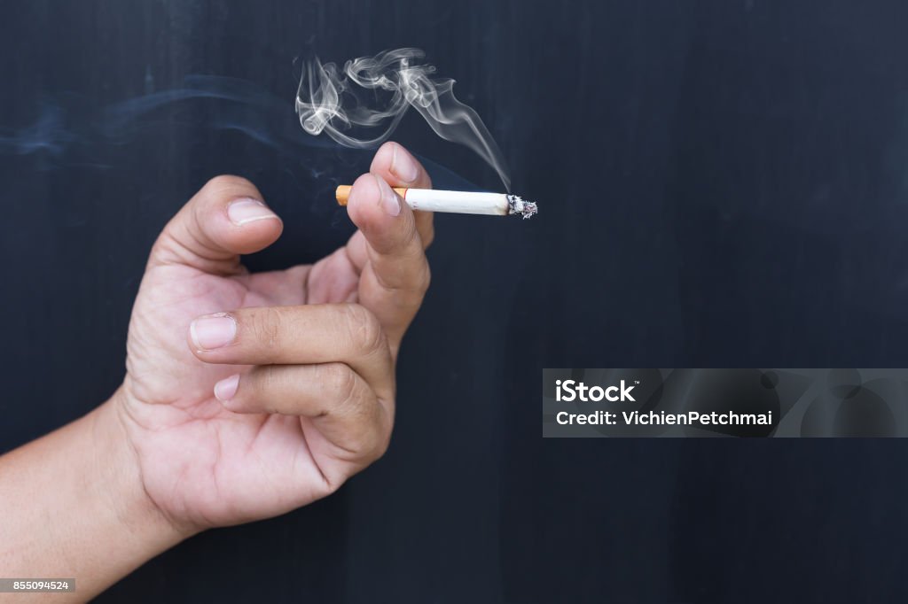 Close up cigarette or tobacco with smoke in hand and copy space"n Smoking - Activity Stock Photo