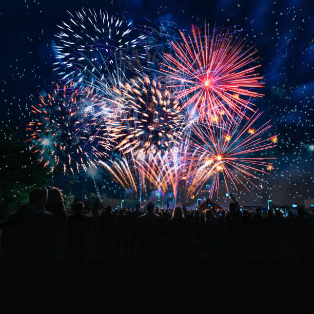 people cheering in front of vibrant firework stock photo