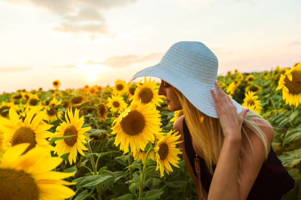 istock Woman with hat on sunflowers field at sunset 855110910