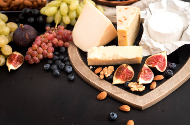 istock different kinds of cheeses, honey, figs, nuts, grapes, and fruit on a table. Selective focus. Copy space 855120424