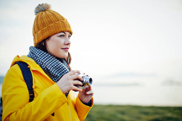 istock Beautiful hiker holding vintage camera against clear sky 855124036