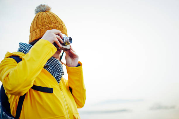 istock Young hiker photographing with vintage camera against clear sky 855124088
