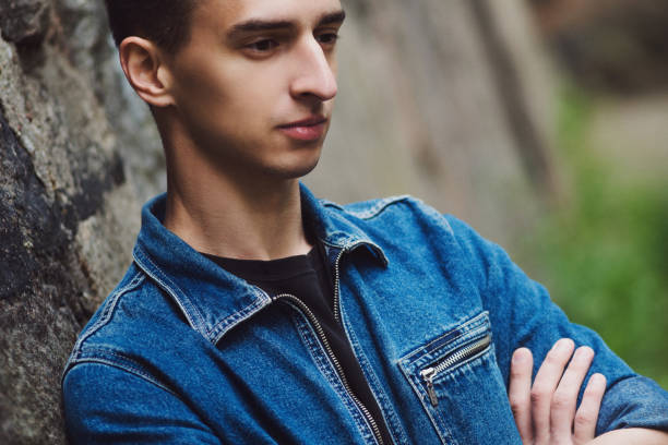 istock Brooding young guy in denim, walks on the street 855127522