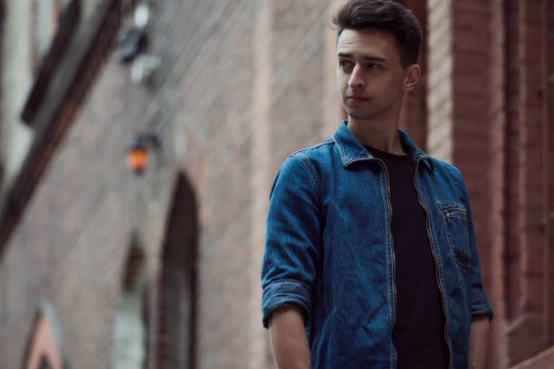 istock young guy in denim, walks on street 855127550