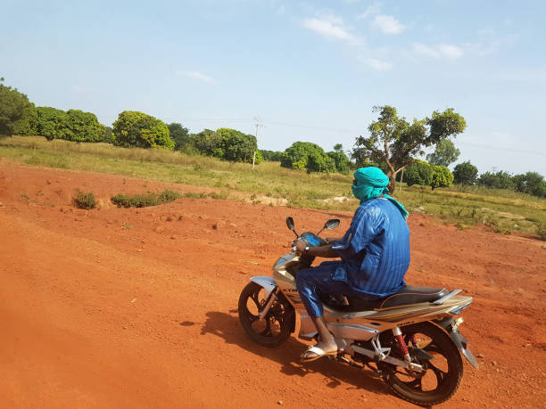 African landscape with Touareg on his KTM bike driving Bamako: African landscape with Touareg on his KTM bike driving fast on the red african soil named animal stock pictures, royalty-free photos & images