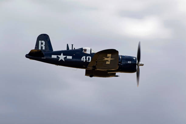 самолет второй мировой войны corsair летит в тяжелых облаках на авиашоу - airshow airplane fighter plane corsair стоковые фото и изображения