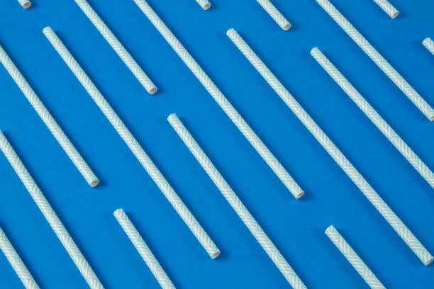 drinking straws on blue background - drinking straw plastic design in a row imagens e fotografias de stock