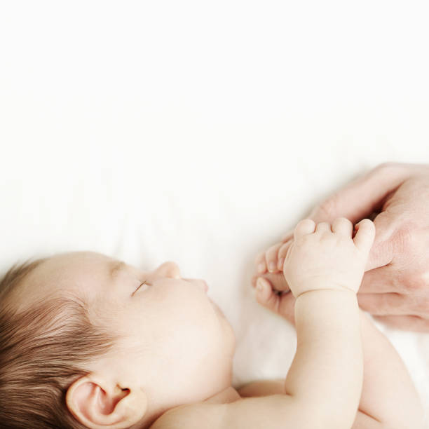 istock Love - baby holding fathers hand, white background 855150424
