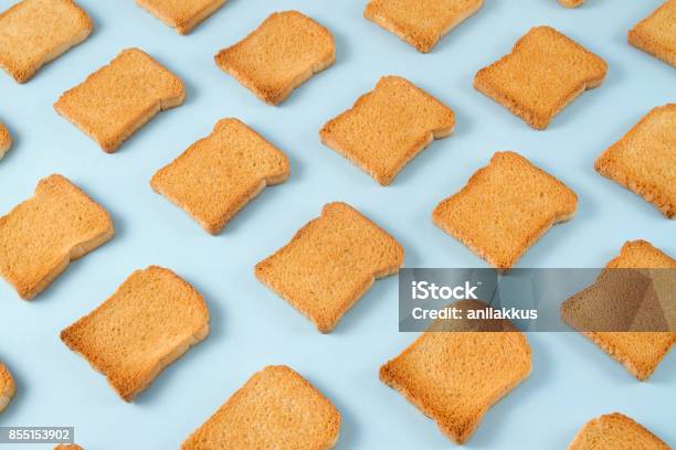 Slice Of Toasted Bread On Blue Background Stock Photo - Download Image Now - Repetition, Colored Background, Bread