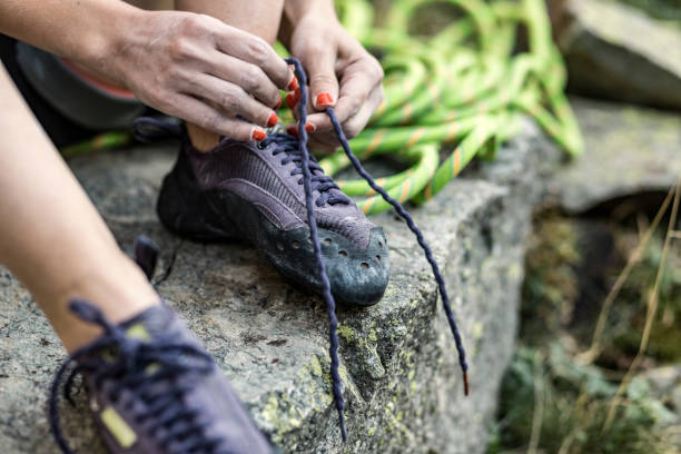 istock Woman tying up her rock climbing shoes 855155140