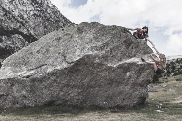 istock Women rock climbers helping each other 855155168