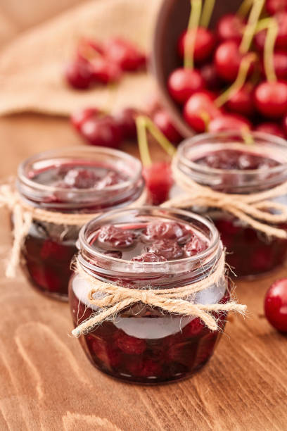 istock Cherry jam on wooden ground 855165904