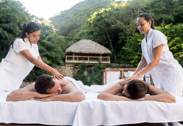 Romantic couple relaxing at the spa and getting a back massage â relationship concepts