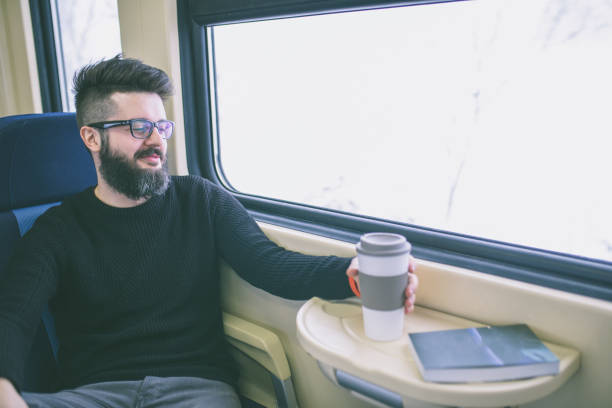 istock Young man travelng in train looking out of window 855169624