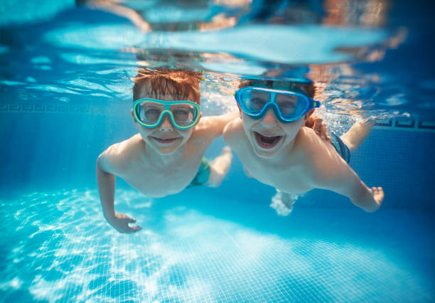 fratellini che vincolano sott'acqua insieme - child swimming pool swimming little boys foto e immagini stock