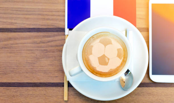 Football ball latte art, coffee next to French flag and smart phone Football ball latte art, top view cup of coffee next to French flag and smart phone, copy space leisure activity french culture sport high angle view stock pictures, royalty-free photos & images