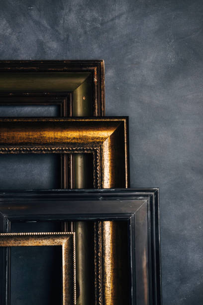 istock Assortment of empty old picture frames leaning against gray wall 855191614