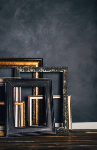 istock Assortment of empty old picture frames leaning against gray wall 855192266