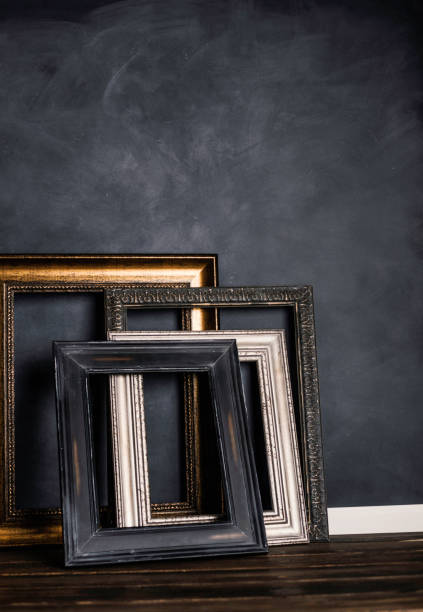 istock Assortment of empty old picture frames leaning against gray wall 855194422