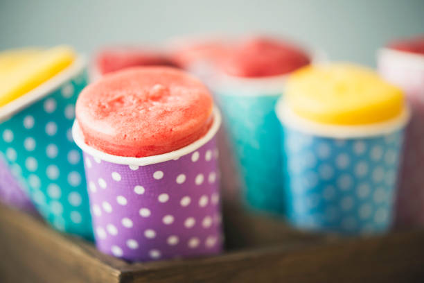 Frozen flavored ice treats in paper cones