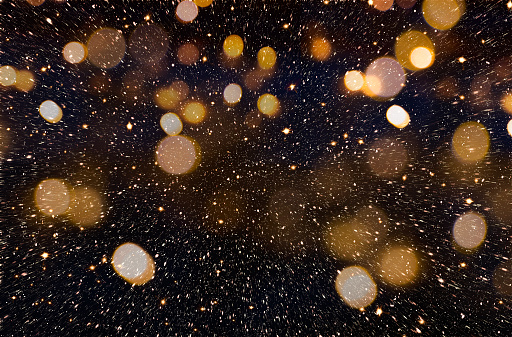 Christmas or New Year celebration background with golden glitter explosion and bokeh