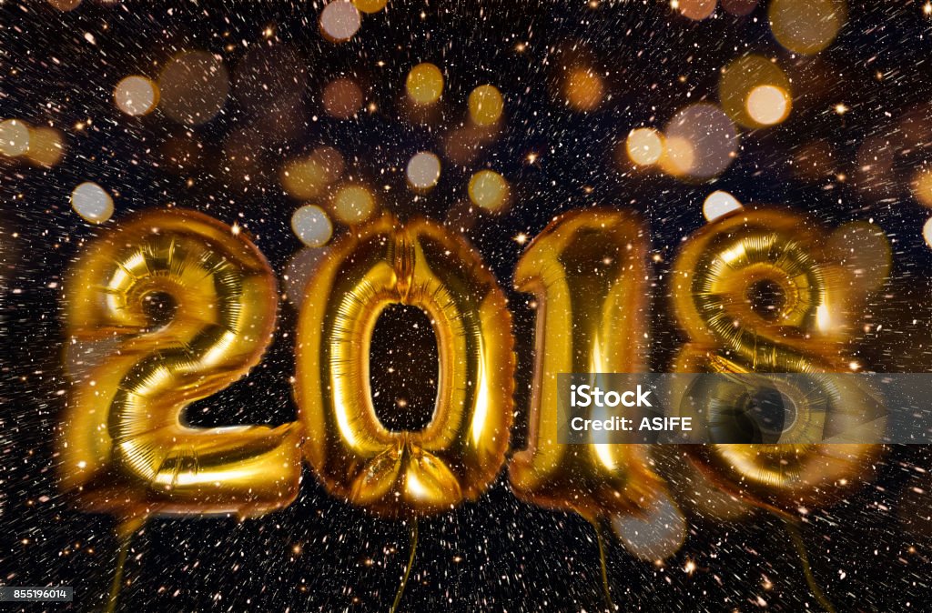 Happy New Year 2018 New year 2018 made with gold balloons floating in a explosion of glitter and bokeh. Motion blur 2018 Stock Photo