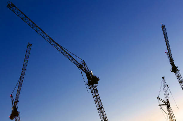 istock Silhouette of Industrial construction cranes at the blue hour. 855202184