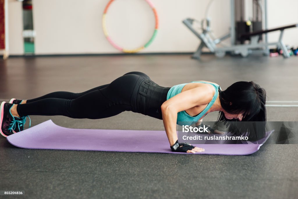 fit girl doing exercises on the floor in the gym fit girl doing exercises on the floor in the gym. Adult Stock Photo