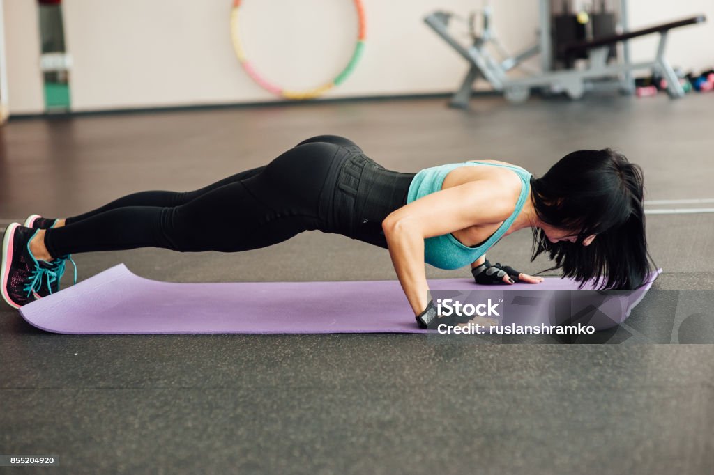 fit girl doing exercises on the floor in the gym fit girl doing exercises on the floor in the gym. Adult Stock Photo