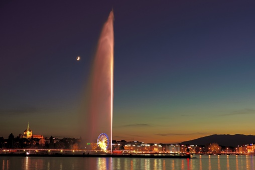 Big fountain of lake Geneva in the sunset and moonlight