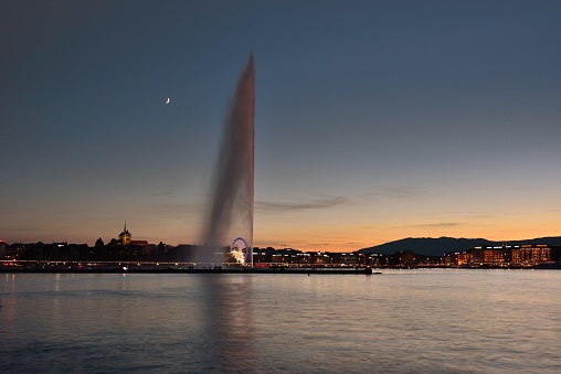 Big fountain of lake Geneva in the sunset and moonlight