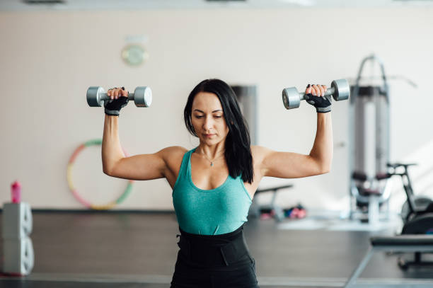 istock woman working out with dumbbells at a gym. 855205598