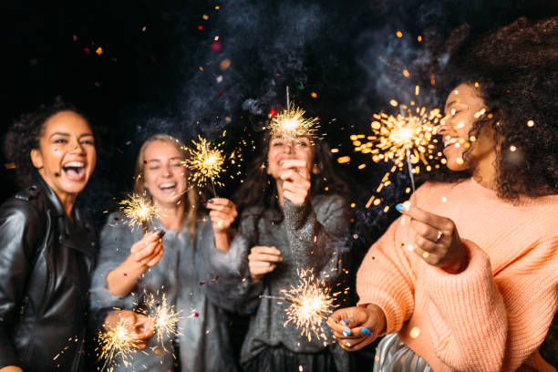 istock Four happy women holding sparklers, throwing confetti 855224054