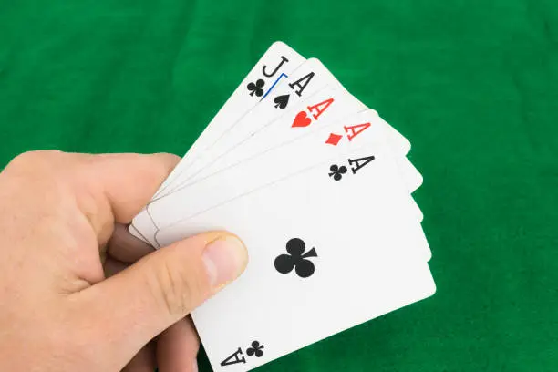 Poker Hand four aces infront of a green backgound