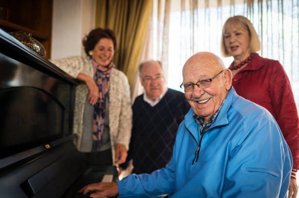 istock Seniors at a piano singing and laughing together looking at camera 855227568
