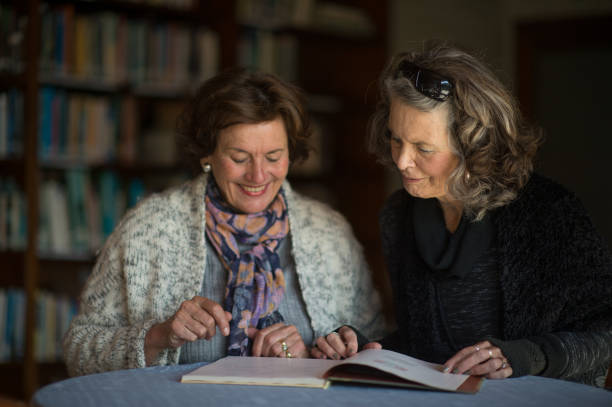 istock Friendly Senior Ladies reading a book together 855230240