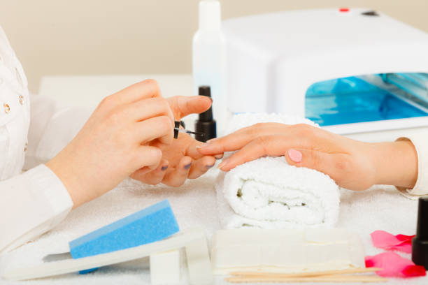istock Woman in beauty salon getting manicure done. 855230442