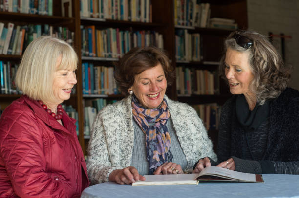 istock Three Friendly Senior Ladies reading a book together 855230662