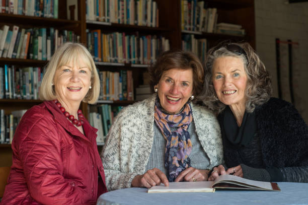 Three Friendly Senior Ladies reading a book together