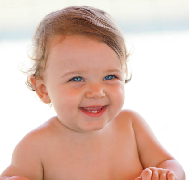 Portrait of a smiling baby girl Portrait at the beach of a smiling one year old baby girl with blue eyes baby teeth stock pictures, royalty-free photos & images