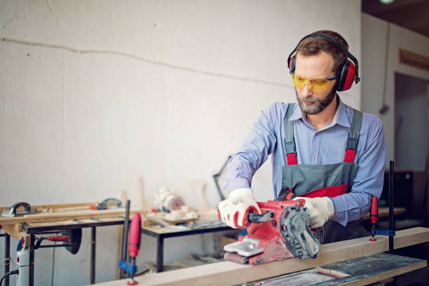 l’homme travaille en collaboration avec la ponceuse en usine de la petite famille charpentier - ear muff photos et images de collection