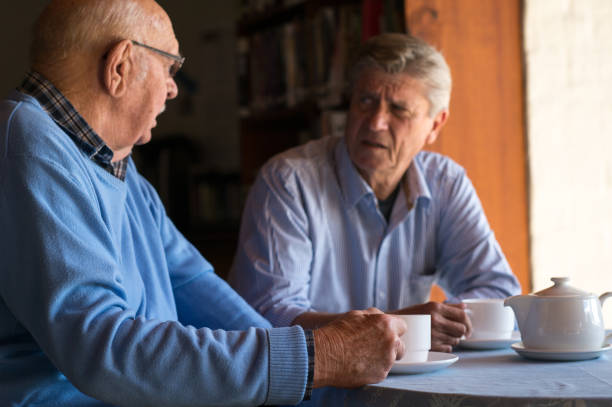 istock Two senior men consoling one another over a cup of coffee 855236390