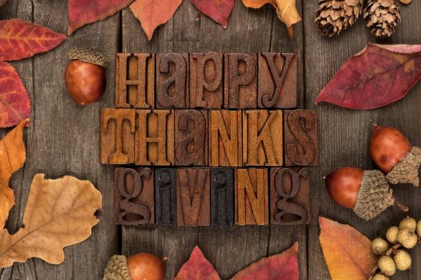 istock Happy Thanksgiving letterpress with frame of autumn leaves over wood 855242548
